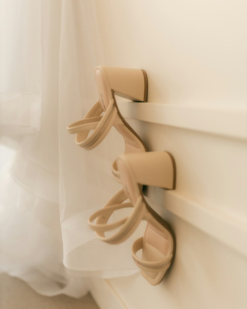 The Heel — beige strappy heels on a white surface